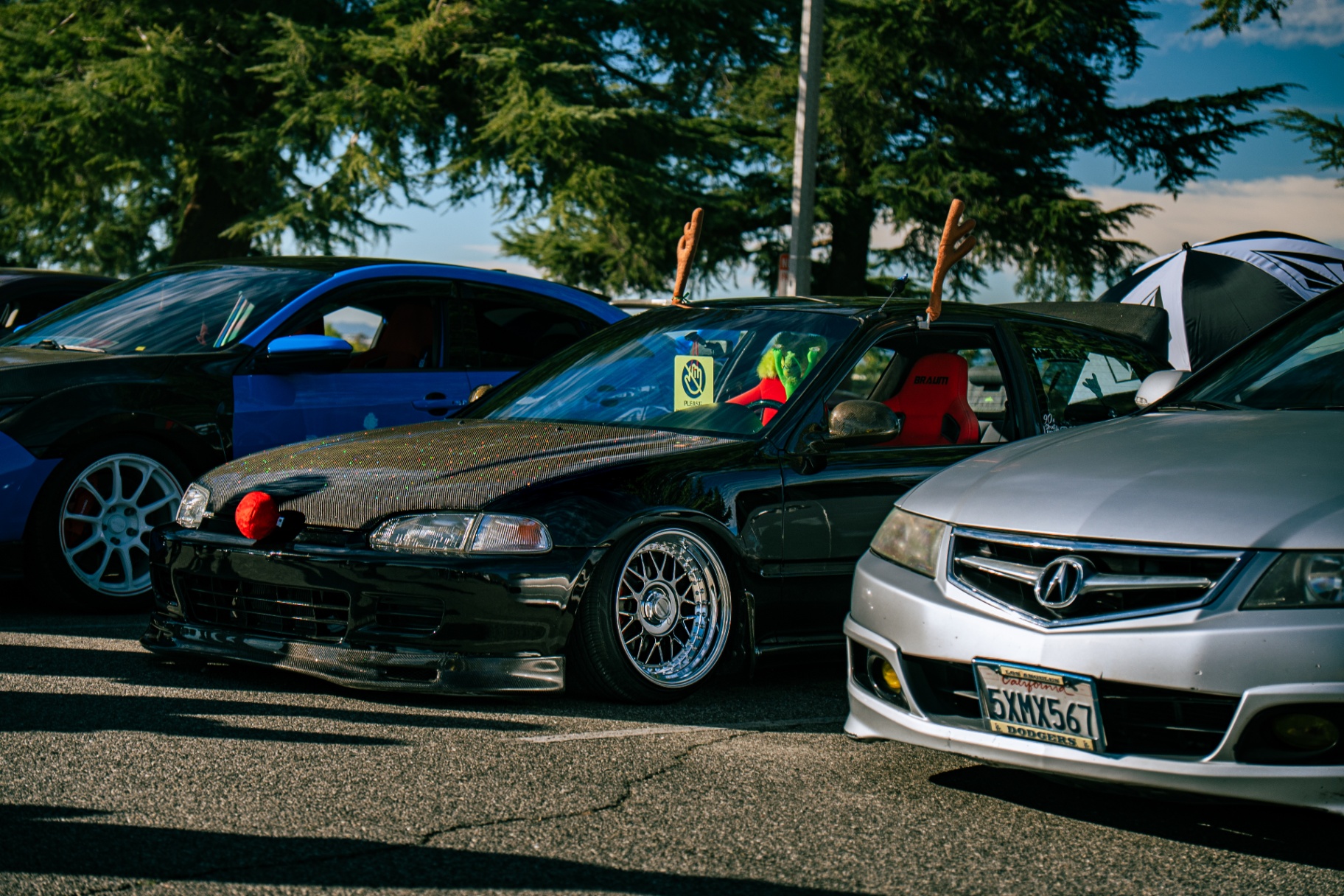 Stanced Honda Civic with festive antlers between an EVO and Acura