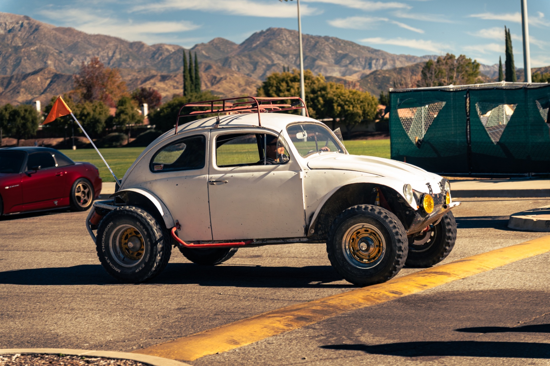 Baja Bug parked with roof rack and off-road tires against a mountain backdrop
