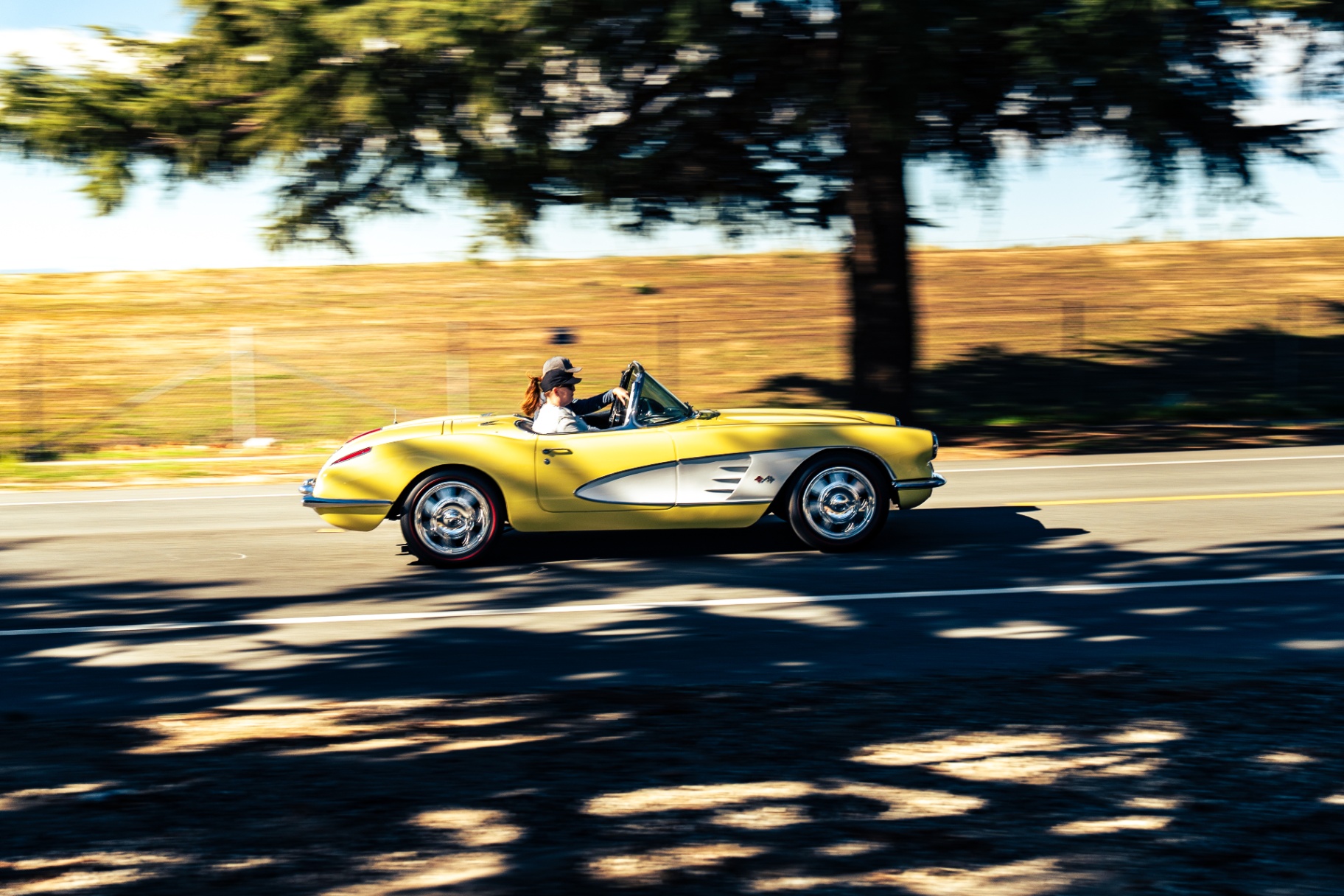 Yellow classic Chevrolet Corvette convertible motion-blur panning shot