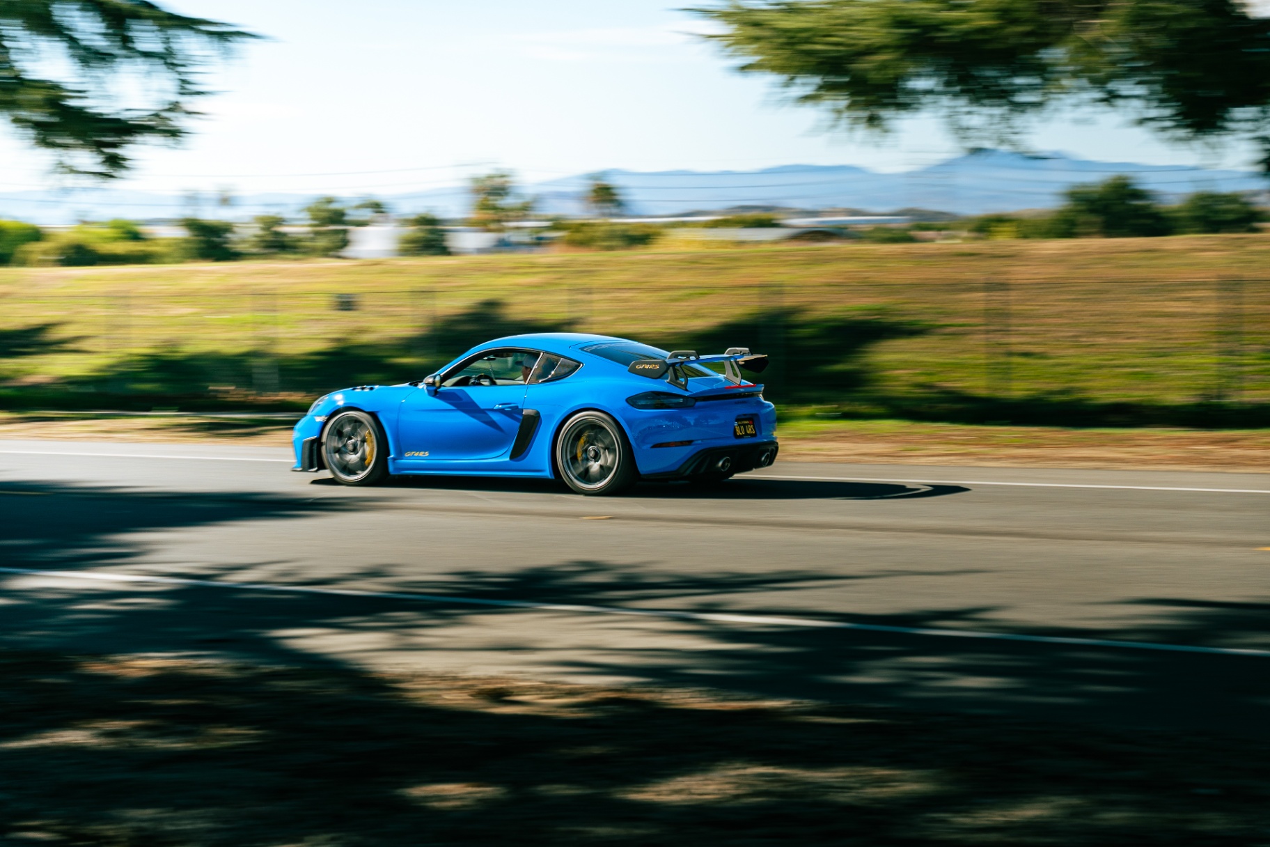 Shark blue Porsche 718 Cayman GT4 RS carving through a corner