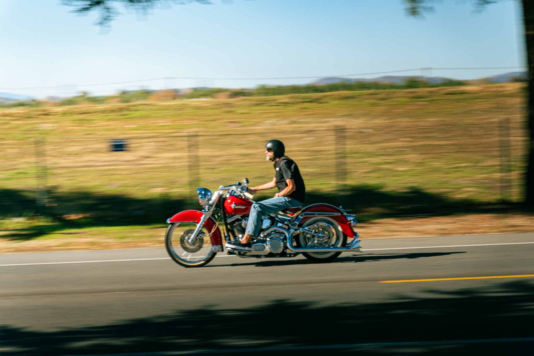 Red Harley cruiser panning down the open road