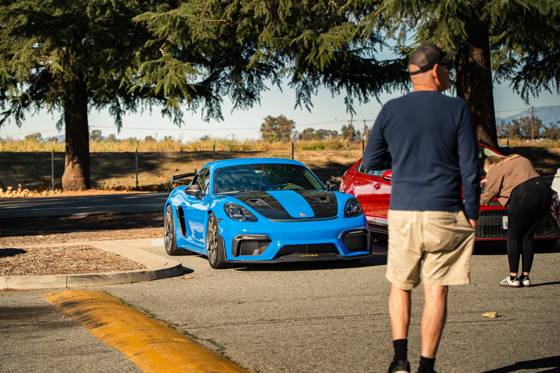 Miami blue Porsche 718 Cayman GT4 RS pulling into the meet